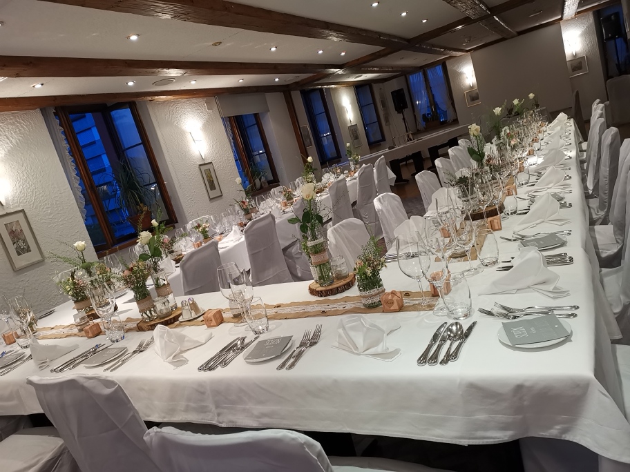 Festlich gedeckter Saal mit weissen Stühlen